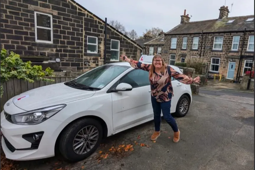 Sarah, driving instructor at Road Ready, beside her Kia Rio