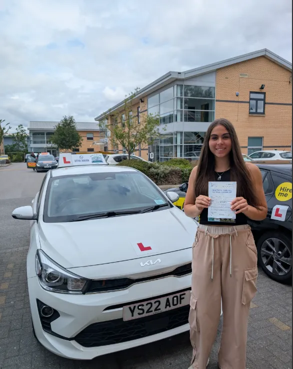 Sarah's student celebrating their driving test pass next to the Road Ready Kia